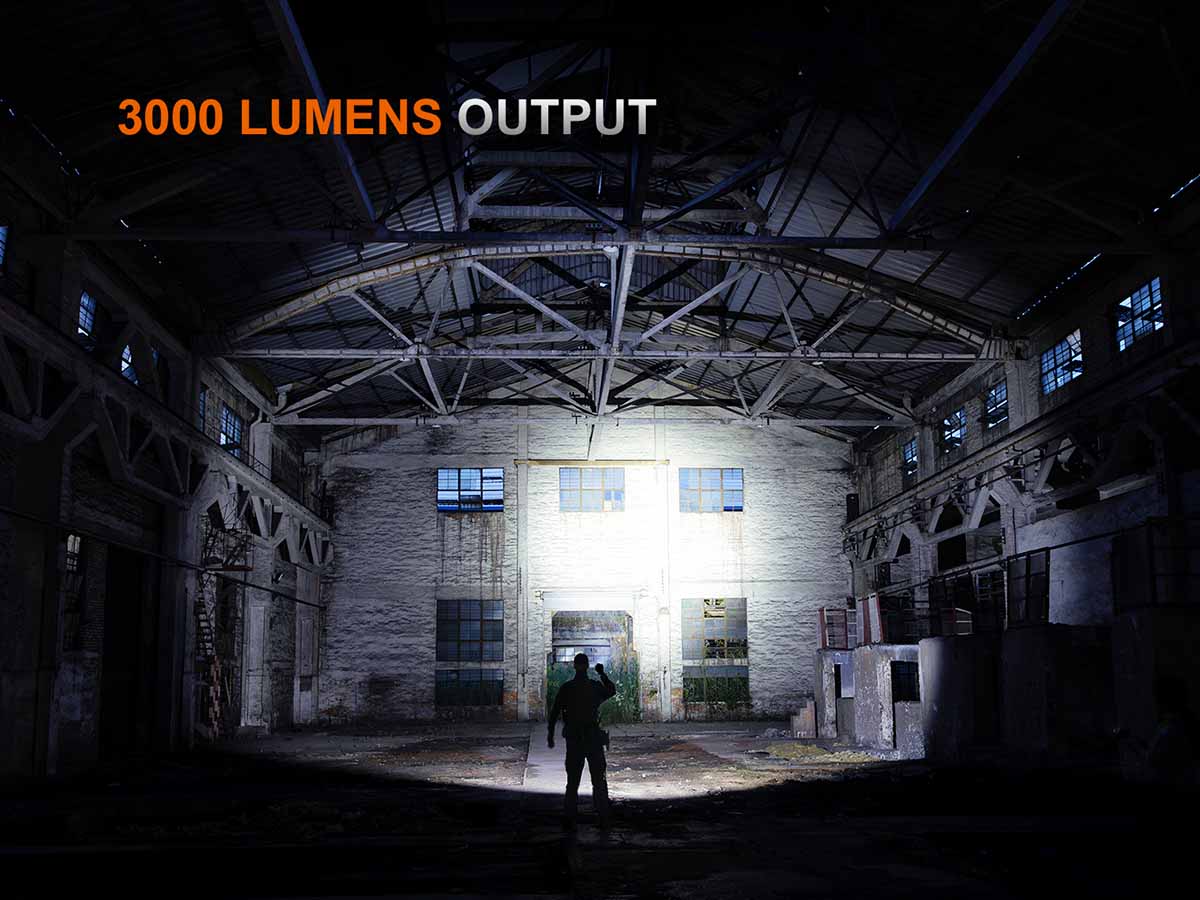 Person standing in a dark warehouse with a light source illuminating the area, highlighting '3000 Lumens Output' text.