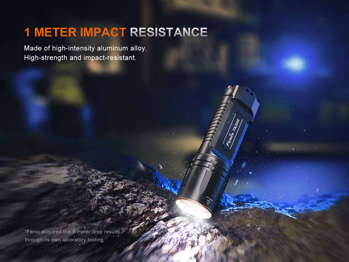 Flashlight with impact resistance feature on a rugged surface at night.